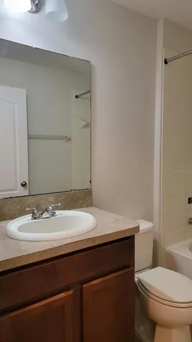 a bathroom with a granite countertop sink mirror and shower