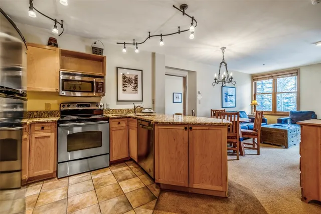 a kitchen with stainless steel appliances kitchen island granite countertop a stove and a sink