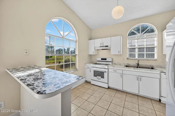 a kitchen with windows and refrigerator