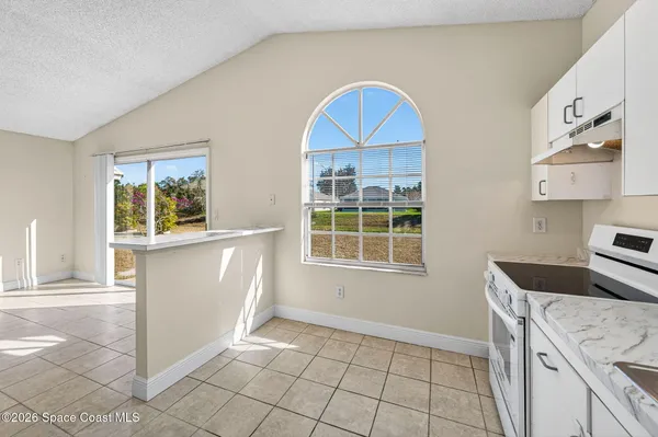 a kitchen with cabinets appliances a sink and a window