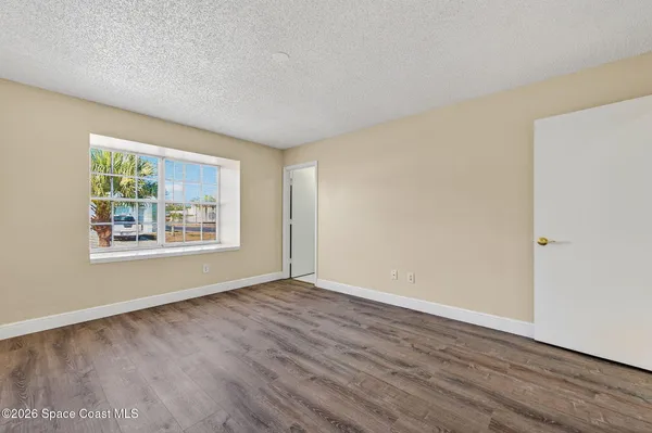 a view of an empty room with wooden floor