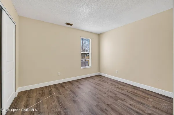 a view of an empty room with wooden floor
