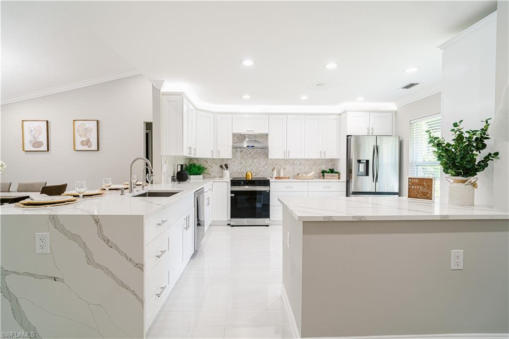 131 25th Street Southwest Naples, FL 34117 - Photo 16 of 50 a kitchen with sink a refrigerator and cabinets
