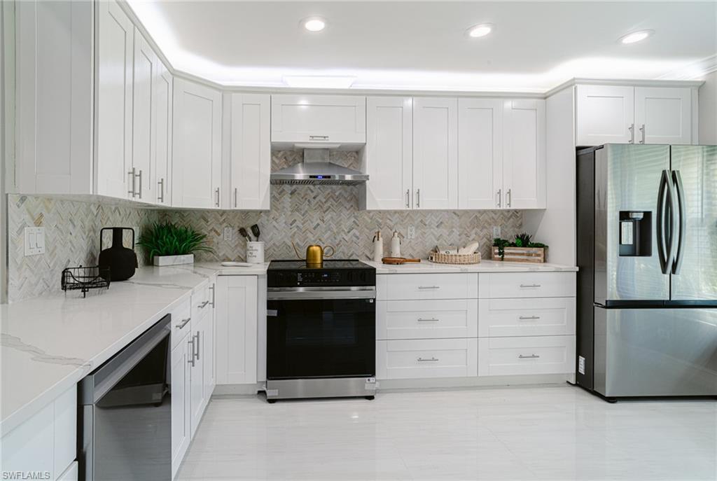 131 25th Street Southwest Naples, FL 34117 - Photo 17 of 50 a kitchen with white cabinets and stainless steel appliances