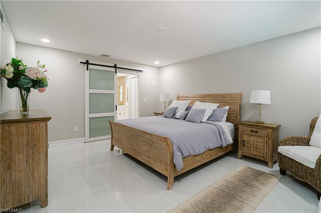 131 25th Street Southwest Naples, FL 34117 - Photo 25 of 50 a spacious bedroom with a bed and a potted plant