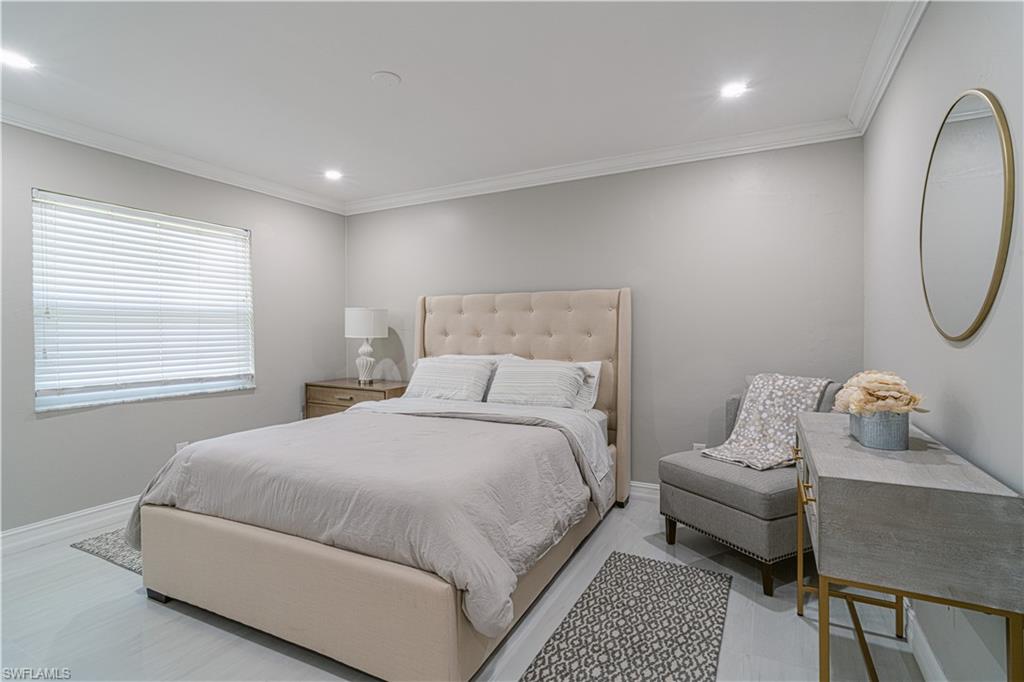 131 25th Street Southwest Naples, FL 34117 - Photo 30 of 50 a bedroom with a bed and a chandelier