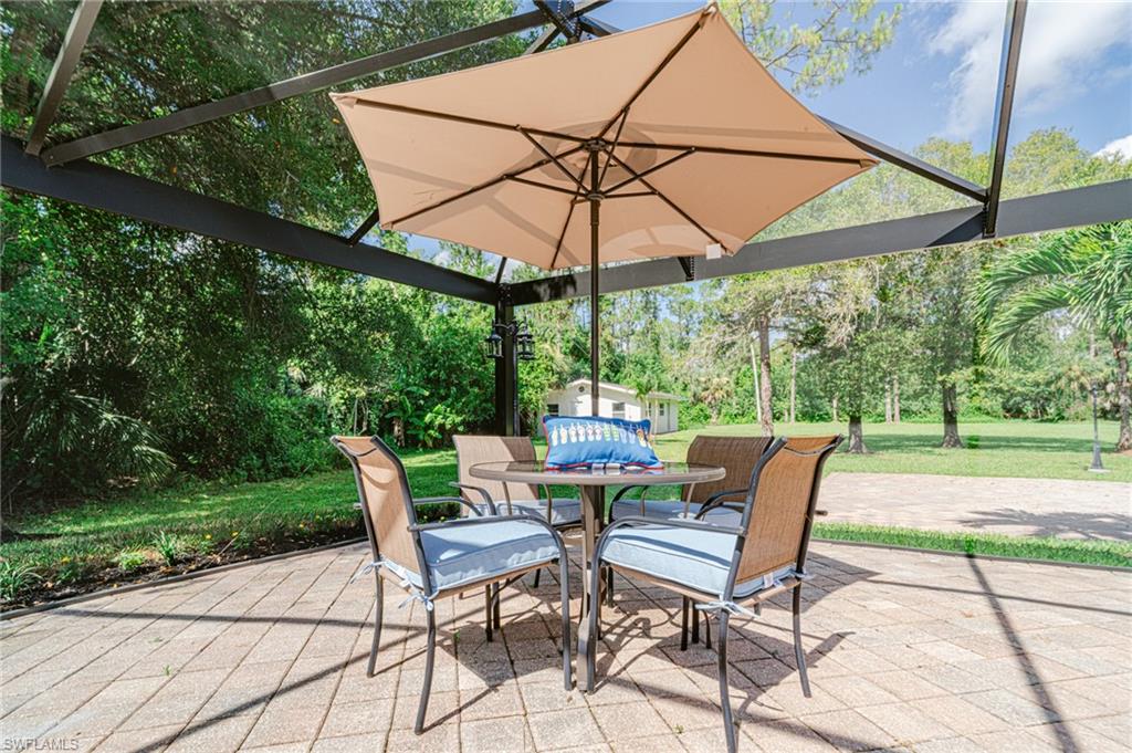 131 25th Street Southwest Naples, FL 34117 - Photo 48 of 50 a view of patio with chairs and table under an umbrella