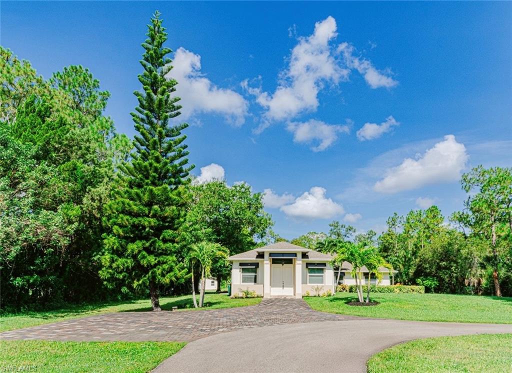 131 25th Street Southwest Naples, FL 34117 - Photo 6 of 50 a front view of a house with a yard and garage