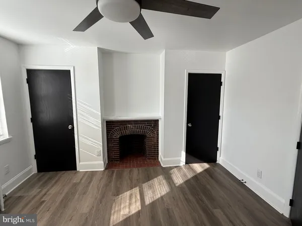 an empty room with wooden floor a ceiling fan and closet