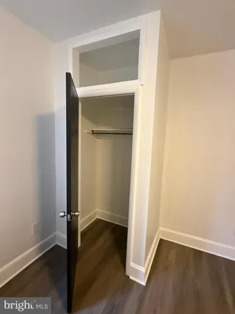 an empty room with wooden floor and closet