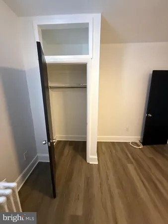 an empty room with wooden floor and mirror