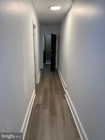 a view of a hallway with wooden floor and closet