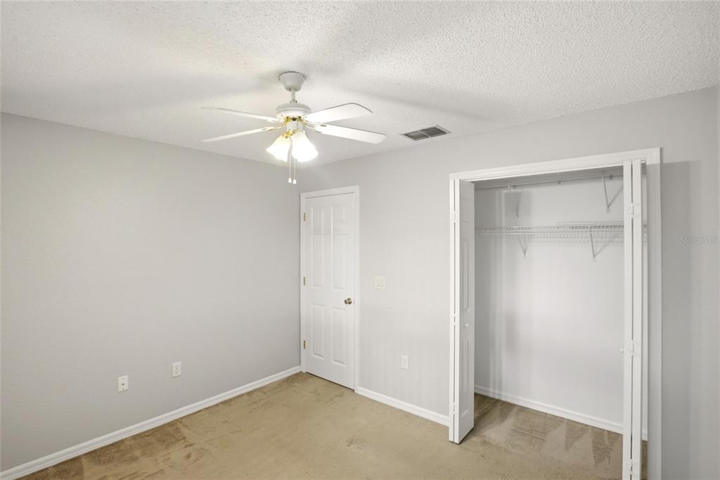 24644 Laurel Ridge Drive Lutz, FL 33559 - Photo 27 of 42 an empty room with a ceiling fan and a window