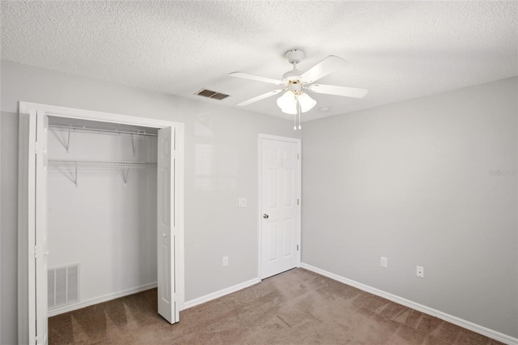 24644 Laurel Ridge Drive Lutz, FL 33559 - Photo 32 of 42 an empty room with a ceiling fan and a window