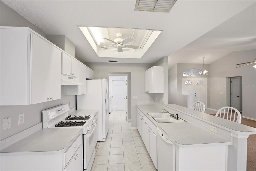 24644 Laurel Ridge Drive Lutz, FL 33559 - Photo 9 of 42 a large white kitchen with stainless steel appliances a stove a sink dishwasher and a refrigerator with wooden floor