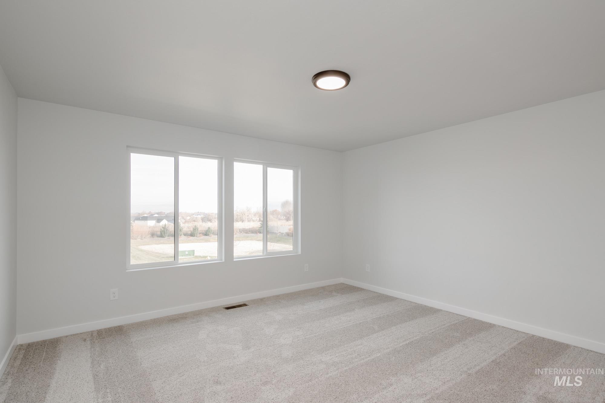 13697 Inman Court Caldwell, ID 83607 - Photo 14 of 23 Unfurnished room with light carpet and baseboards