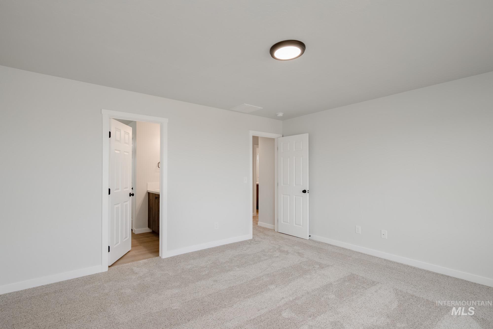 13697 Inman Court Caldwell, ID 83607 - Photo 15 of 23 Unfurnished bedroom featuring light colored carpet and ensuite bath