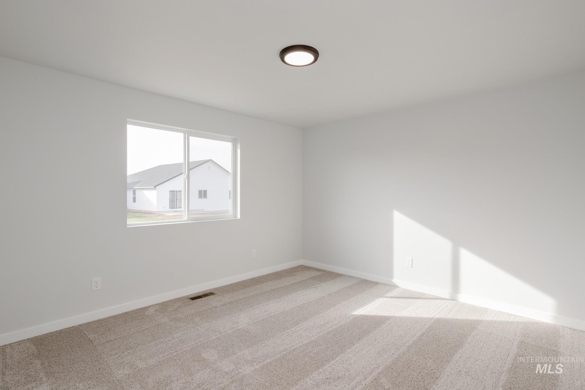 13697 Inman Court Caldwell, ID 83607 - Photo 20 of 23 Spare room with light carpet and baseboards
