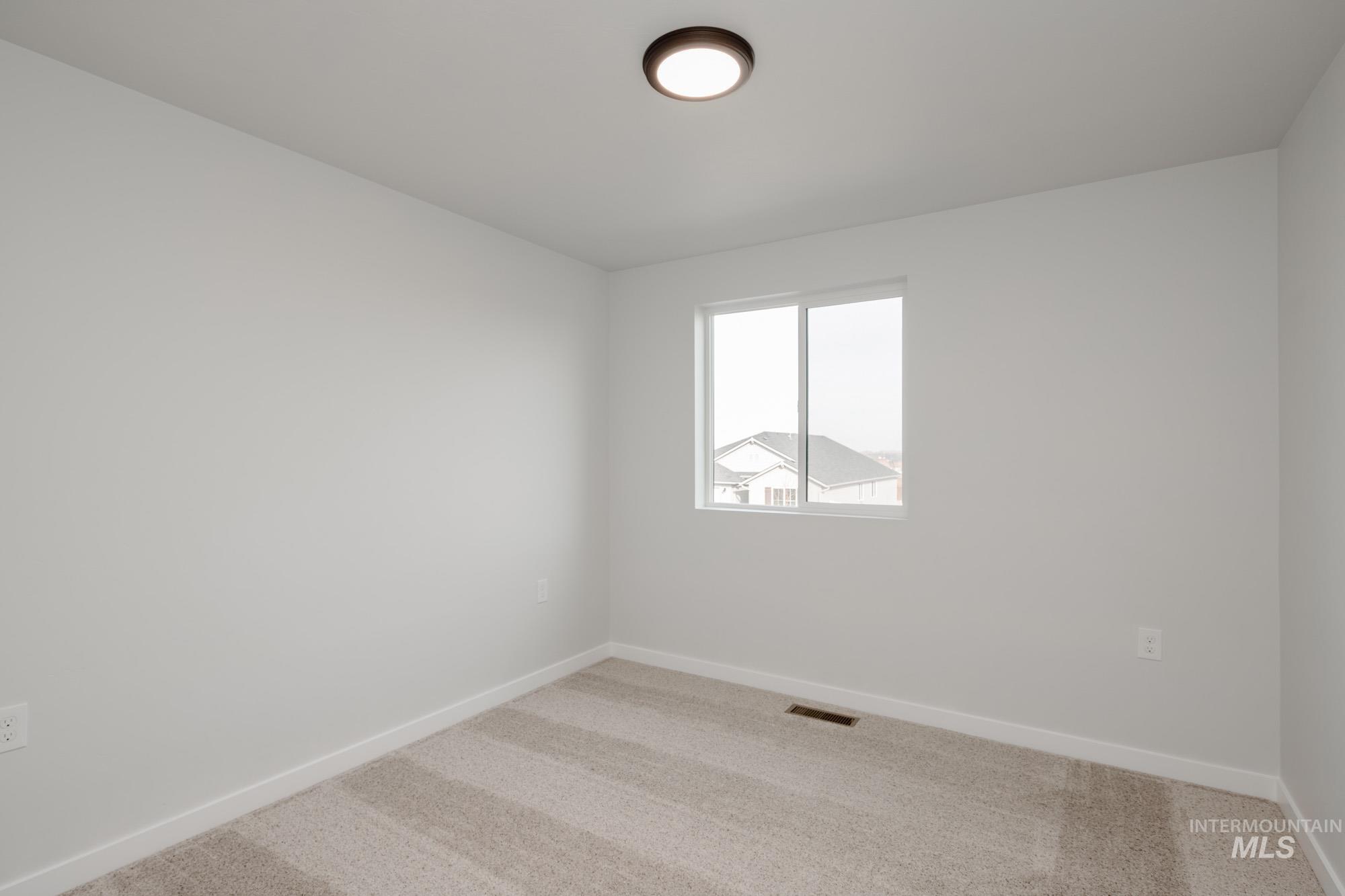 13697 Inman Court Caldwell, ID 83607 - Photo 22 of 23 Carpeted spare room featuring baseboards