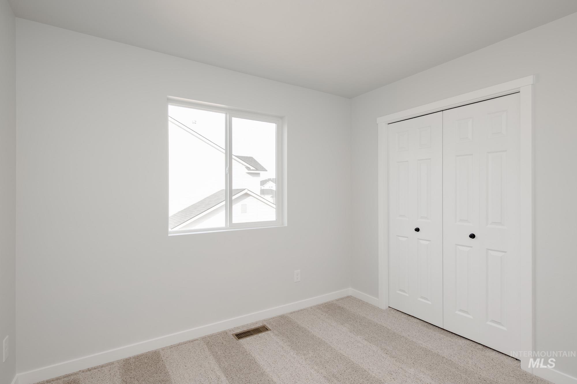 13697 Inman Court Caldwell, ID 83607 - Photo 23 of 23 Unfurnished bedroom with light carpet and a closet