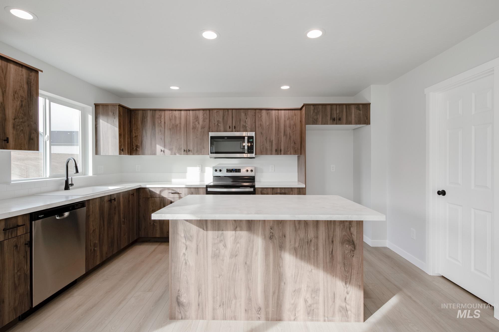 13697 Inman Court Caldwell, ID 83607 - Photo 4 of 23 Kitchen with stainless steel appliances, a kitchen island, recessed lighting, modern cabinets, and light wood-type flooring
