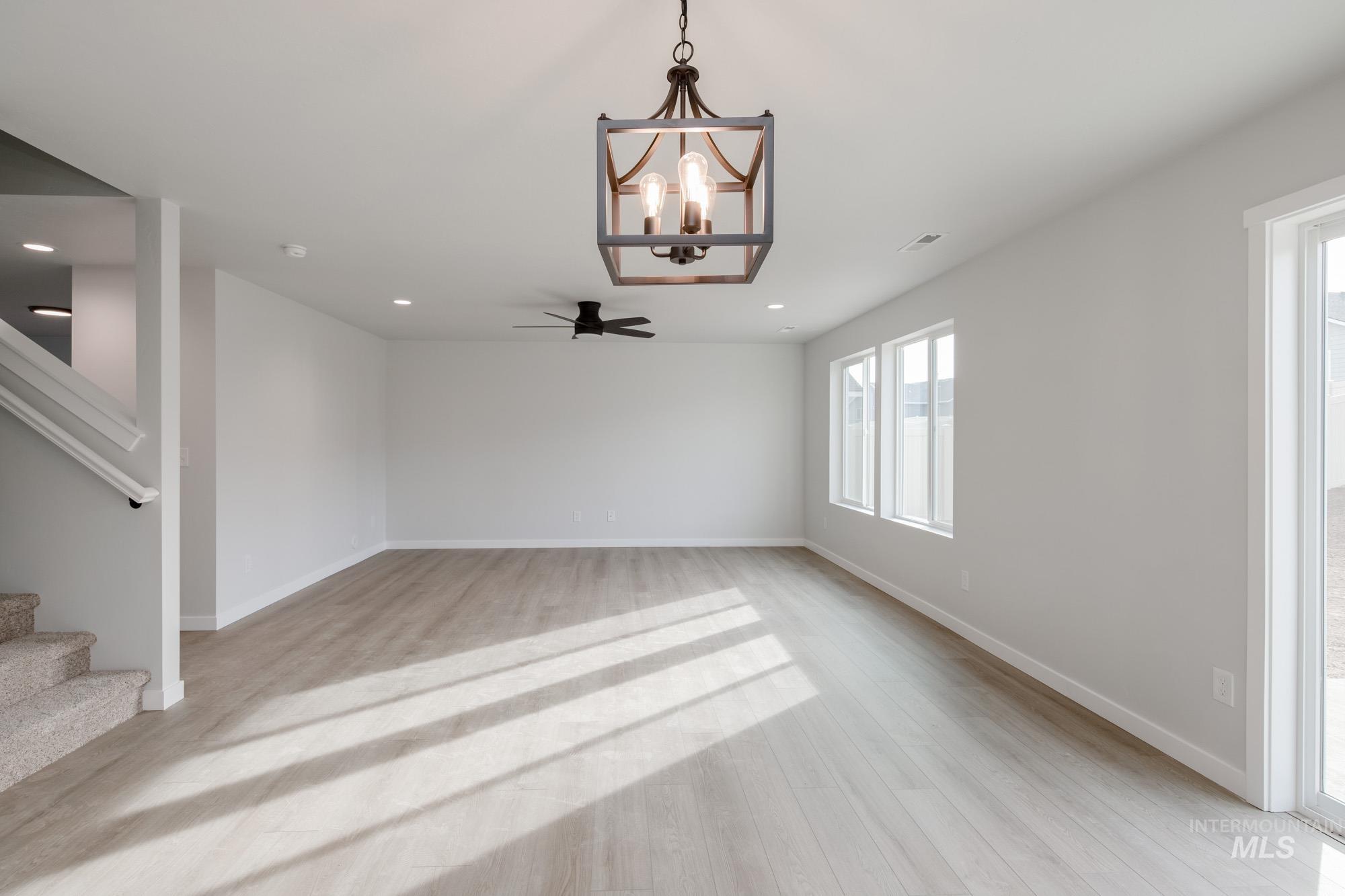 13697 Inman Court Caldwell, ID 83607 - Photo 5 of 23 Unfurnished dining area featuring a chandelier, light wood finished floors, and ceiling fan