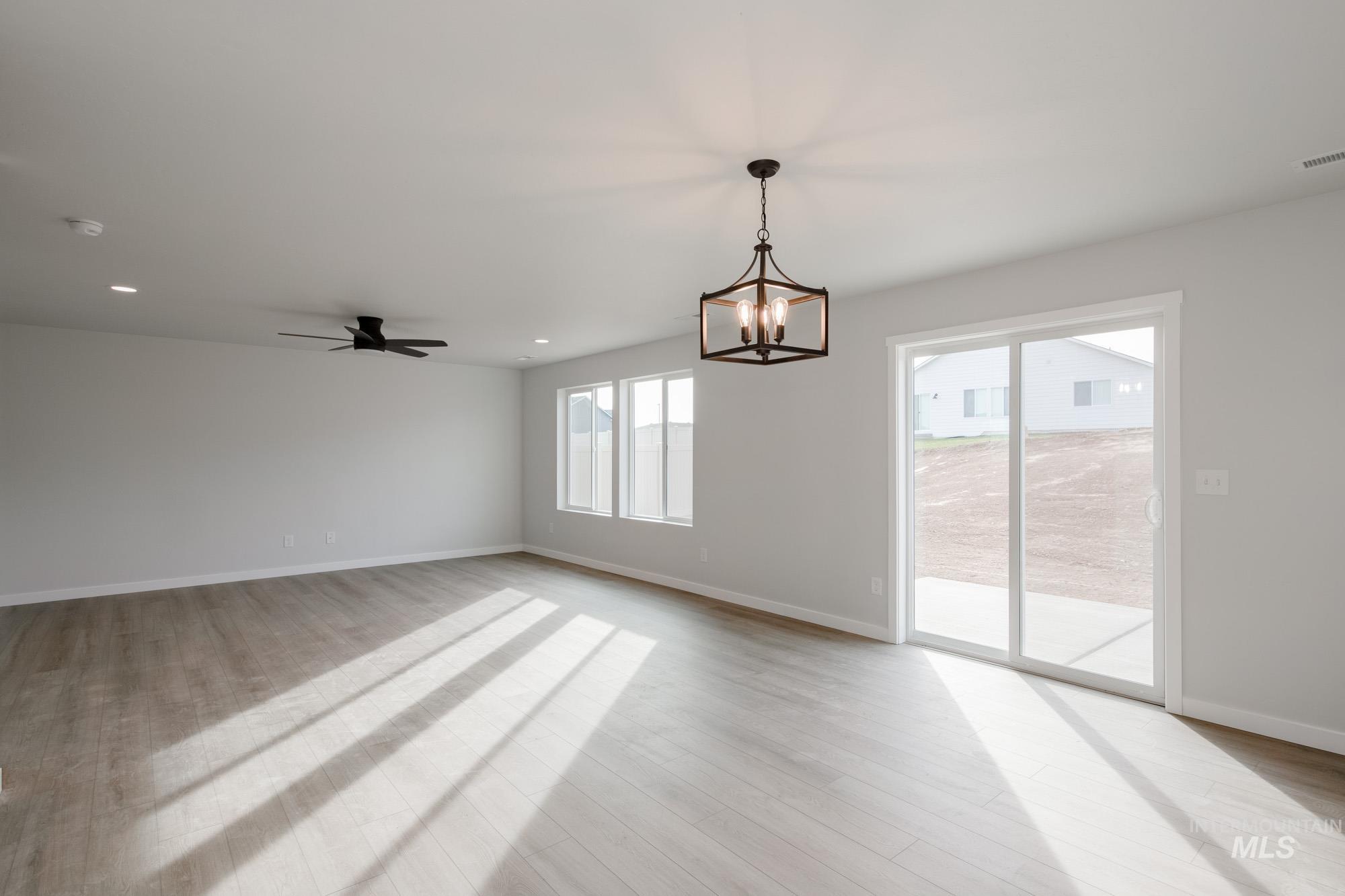 13697 Inman Court Caldwell, ID 83607 - Photo 9 of 23 Empty room featuring suspended lighting, ceiling fan, and light wood-style floors