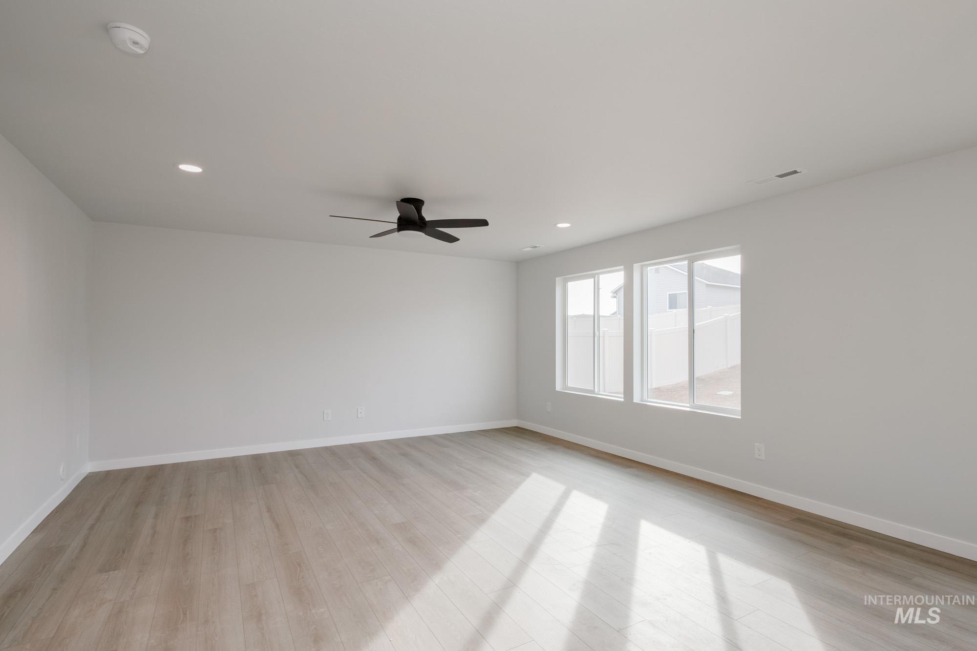 13697 Inman Court Caldwell, ID 83607 - Photo 10 of 23 Unfurnished room featuring light wood-style flooring, ceiling fan, and recessed lighting