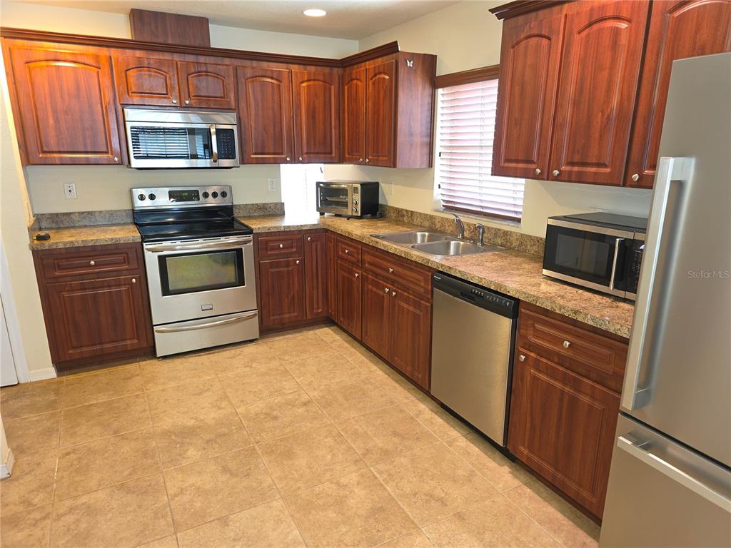 4284 High Ridge Avenue Spring Hill, FL 34609 - Photo 3 of 40 a kitchen with granite countertop a stove top oven microwave and cabinets