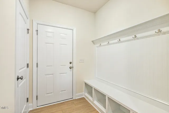 an empty room with wooden floor fireplace and windows