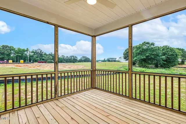 a view of a room with wooden floor and kitchen view