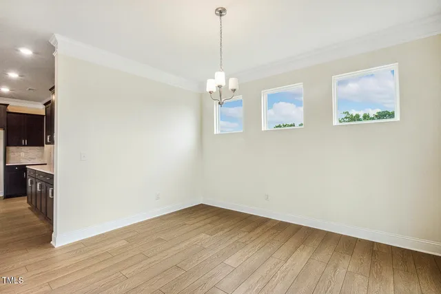 a view of a room with wooden floor fireplace and windows