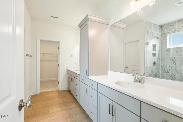 a spacious bathroom with a double vanity sink mirror double and shower