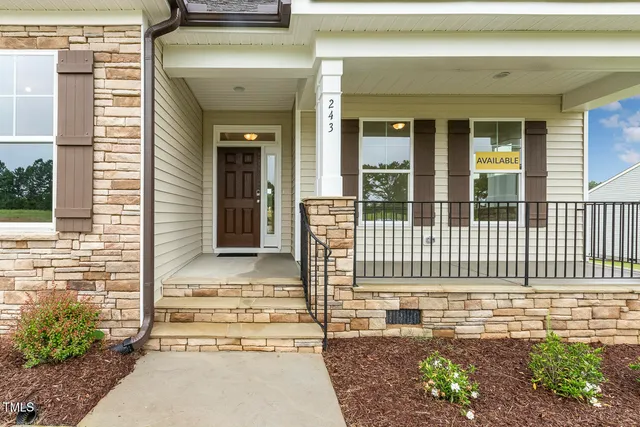 a view of a house with a small yard and wooden floor and fence