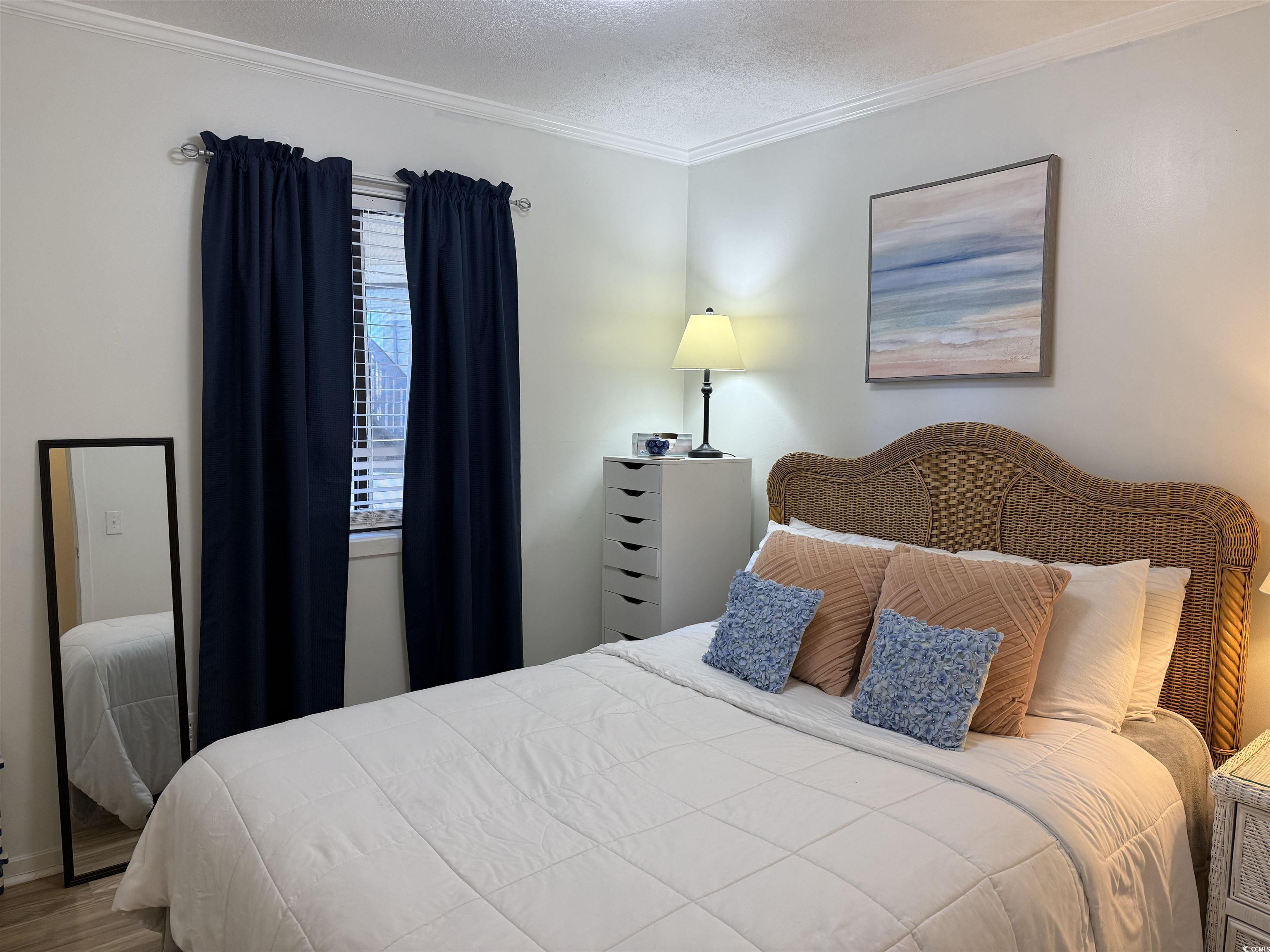 4350 Intercoastal Drive, Unit INTERCOASTAL VILLAGE UNI Little River, SC 29566 - Photo 14 of 21 Bedroom featuring a textured ceiling, ornamental molding, and wood finished floors