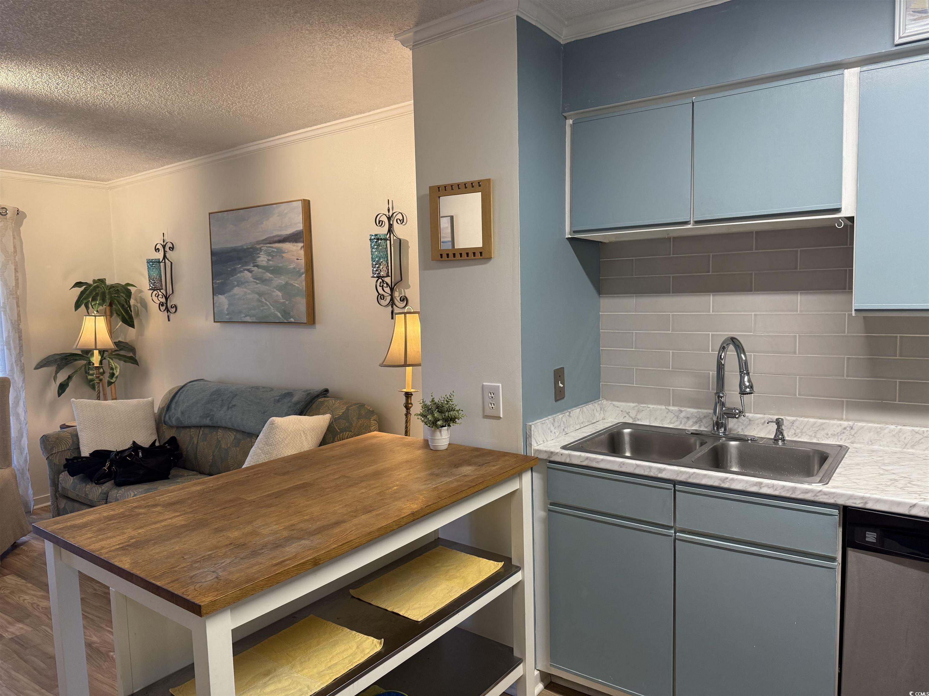 4350 Intercoastal Drive, Unit INTERCOASTAL VILLAGE UNI Little River, SC 29566 - Photo 21 of 21 Kitchen featuring gray cabinetry, a textured ceiling, crown molding, light countertops, and tasteful backsplash