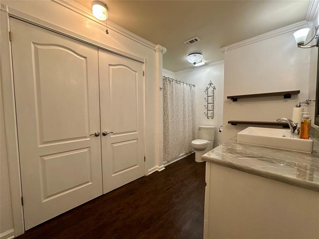 2734 Mildred Street Waco, TX 76706 - Photo 16 of 32 Full bathroom with vanity, a shower with curtain, dark wood-style flooring, and ornamental molding