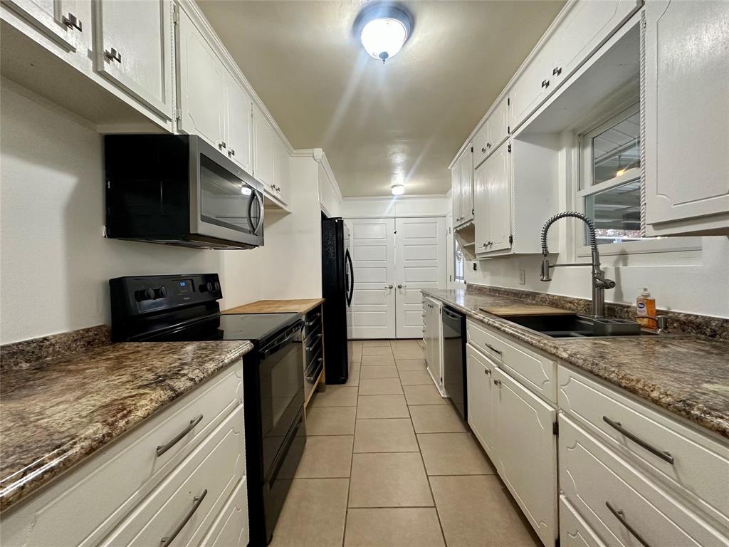 2734 Mildred Street Waco, TX 76706 - Photo 9 of 32 Kitchen with black appliances, white cabinetry, and light tile patterned floors