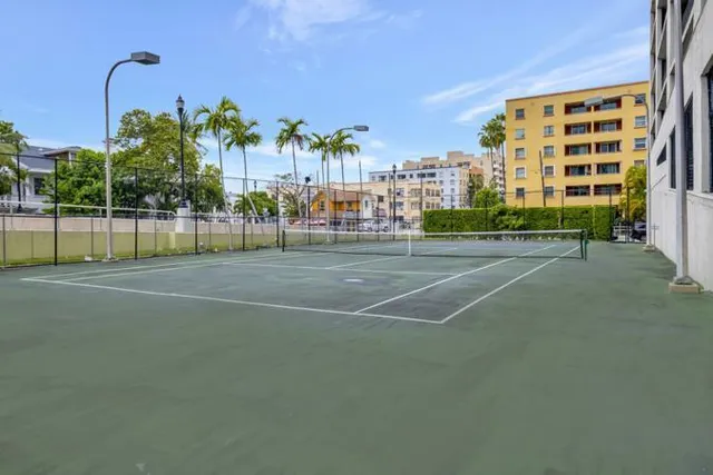 a view of a tall building with a lawn chairs and palm trees
