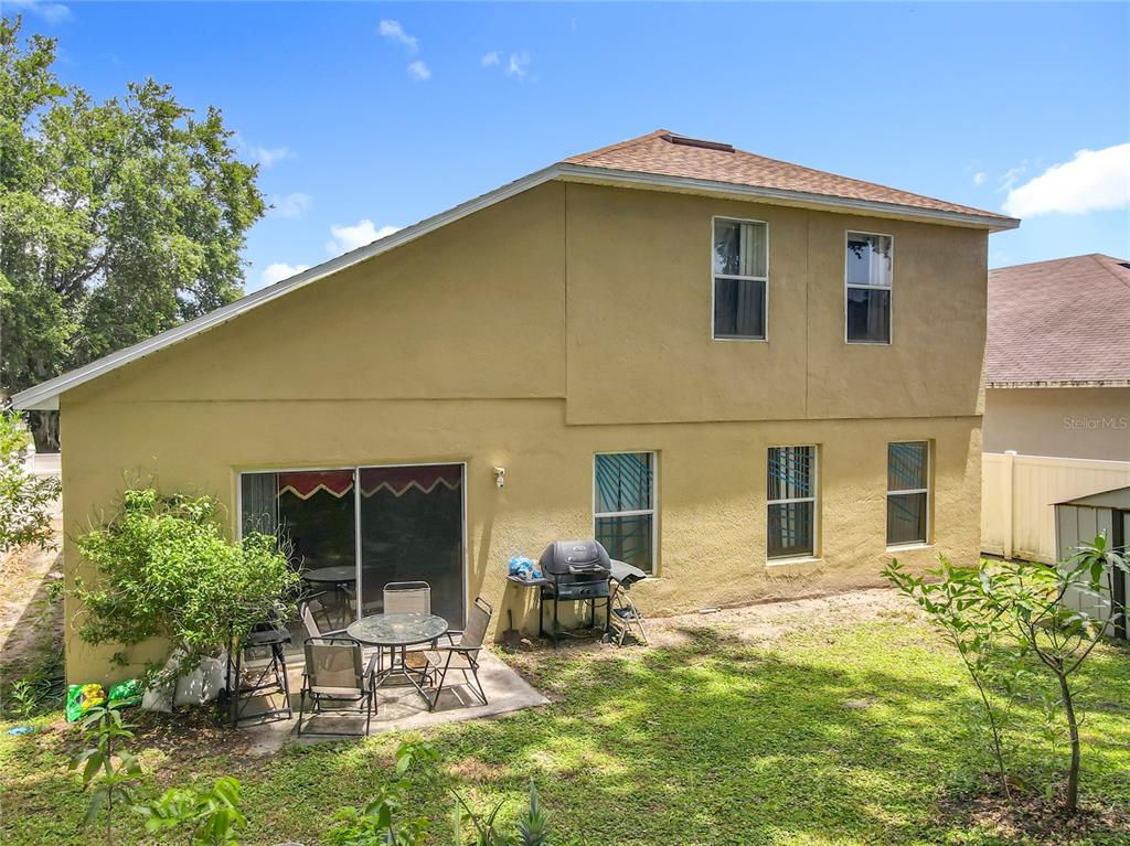 7939 Riffle Lane Orlando, FL 32818 - Photo 40 of 52 a backyard of a house with table and chairs and potted plants