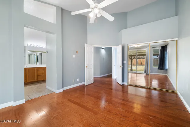 a view of a hallway with wooden floor and a living room
