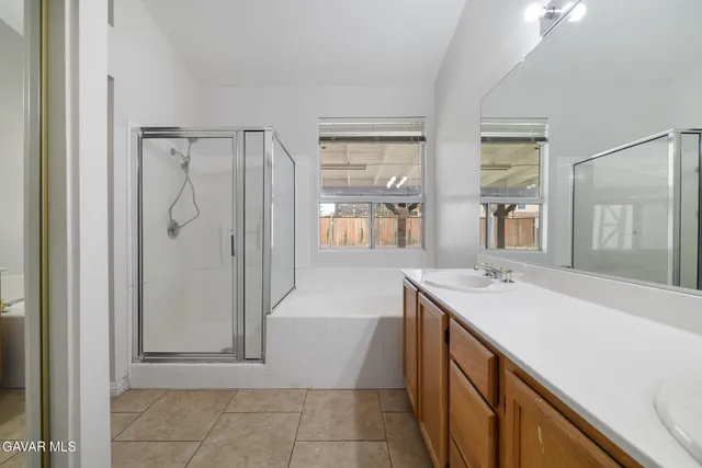 a bathroom with a shower sink and mirror