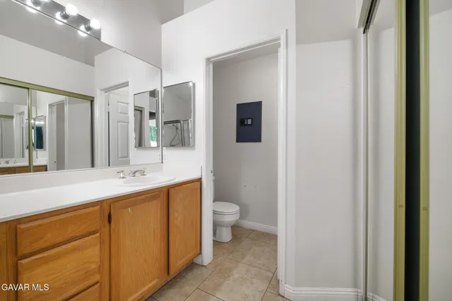 a bathroom with a double vanity sink toilet and mirror