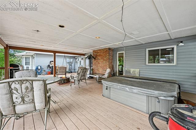 1263 York Road Colorado Springs, CO 80918 - Photo 23 of 29 Deck with a hot tub and an outdoor fire pit
