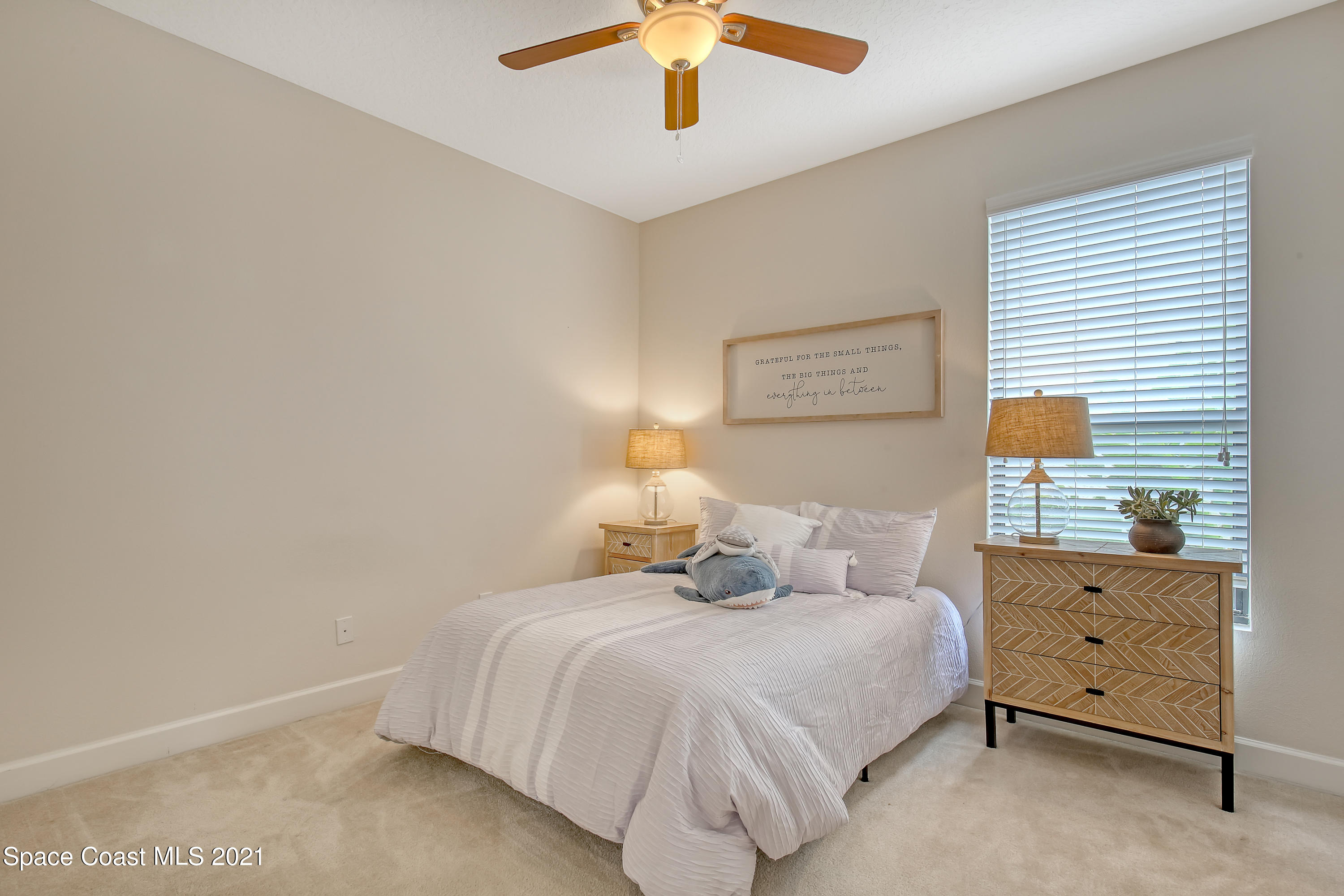 1380 Talon Way Melbourne, FL 32934 - Photo 27 of 59 a bedroom with a bed and a chandelier