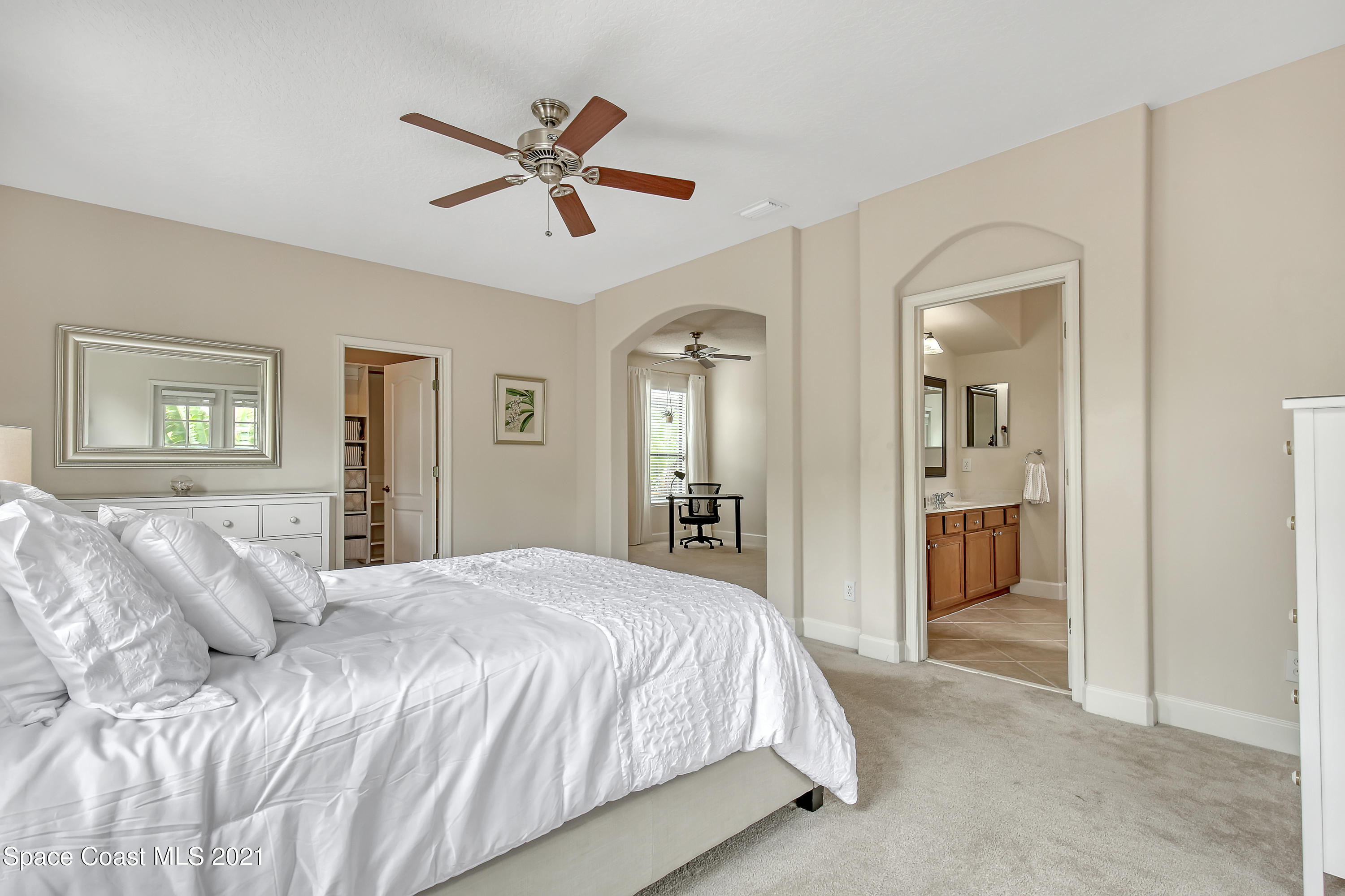 1380 Talon Way Melbourne, FL 32934 - Photo 32 of 59 a bedroom with a large bed and a chandelier