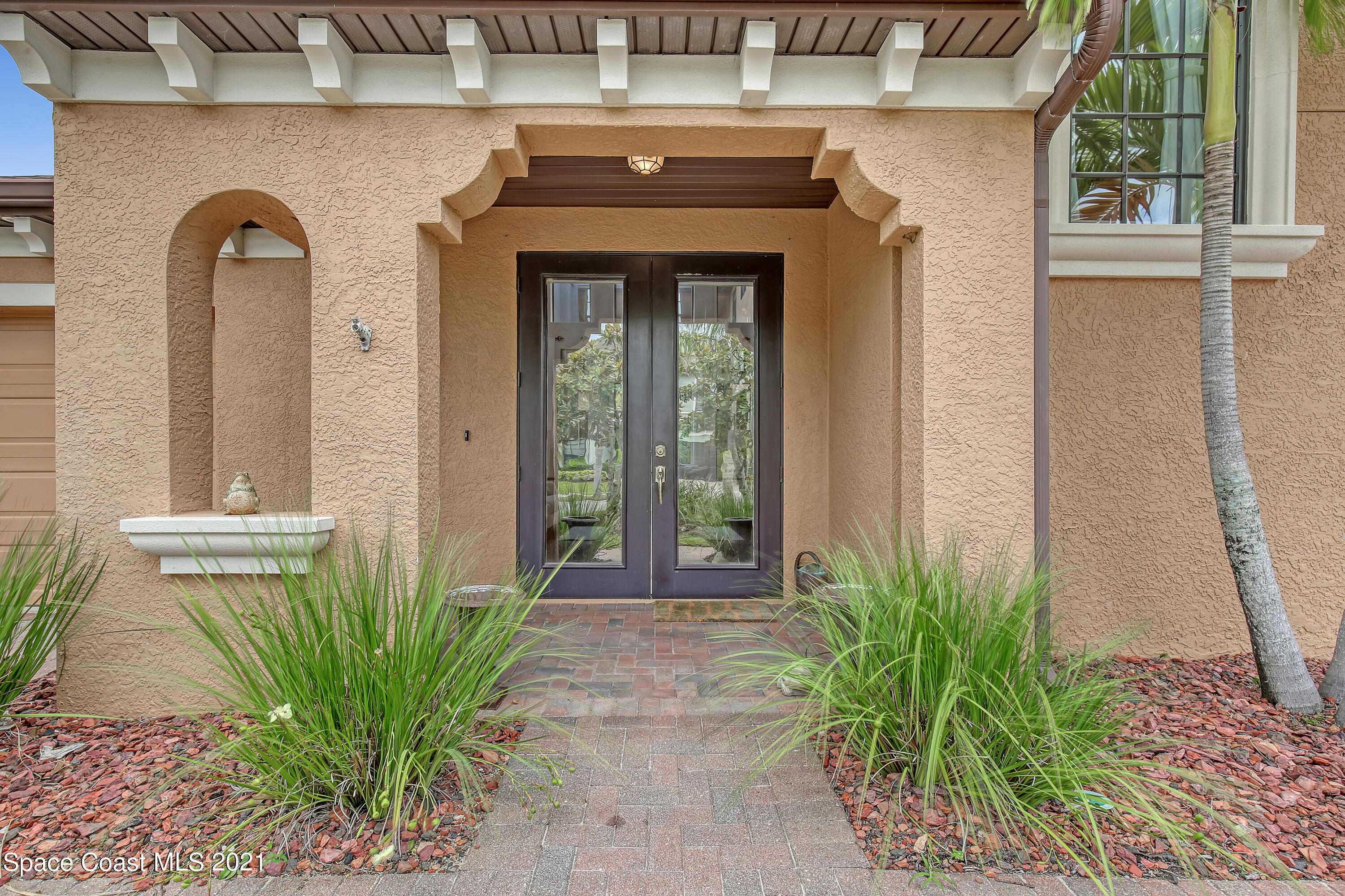 1380 Talon Way Melbourne, FL 32934 - Photo 4 of 59 a front view of a house with a garden