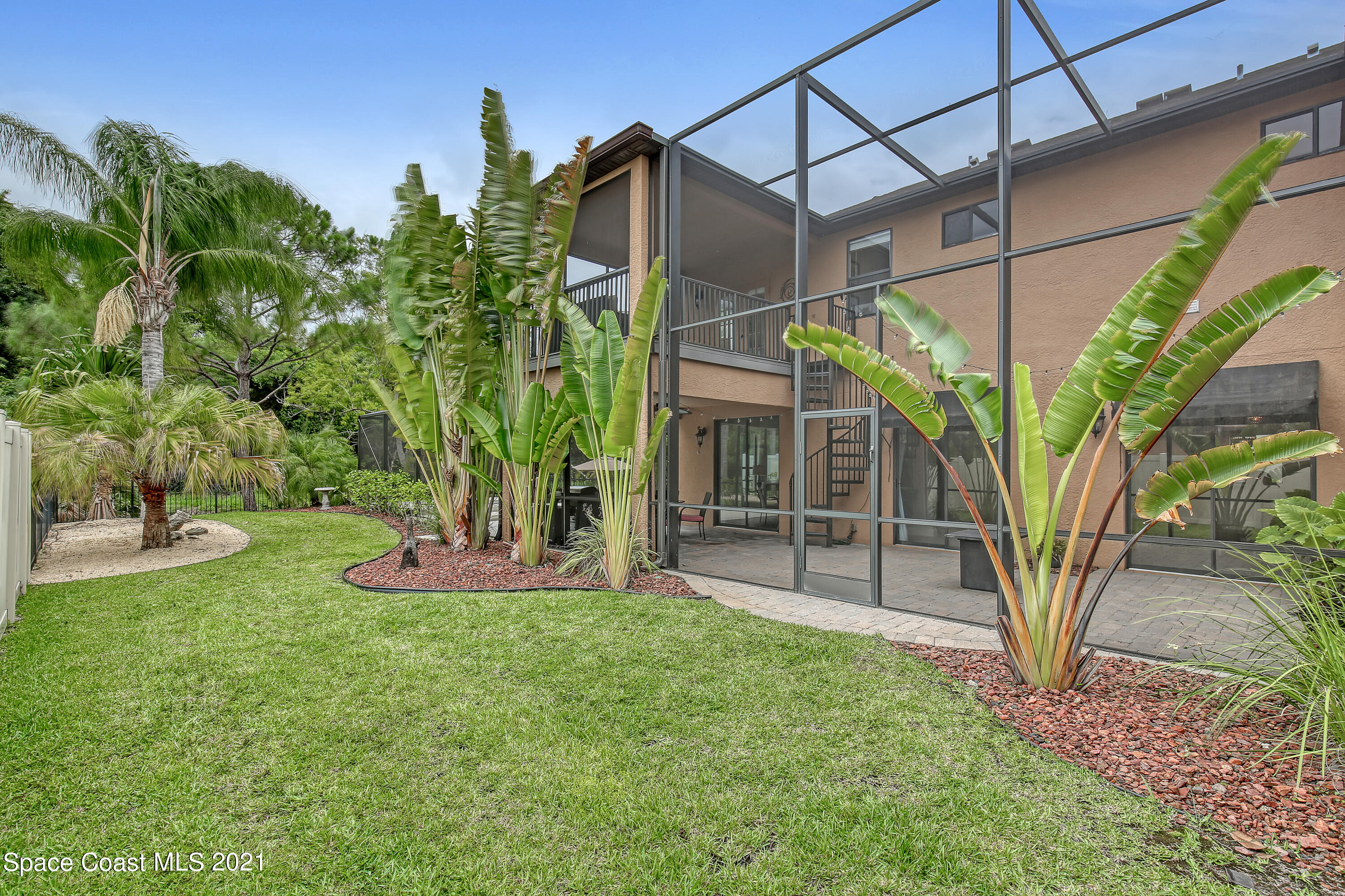 1380 Talon Way Melbourne, FL 32934 - Photo 52 of 59 a view of a backyard with plants and a large tree