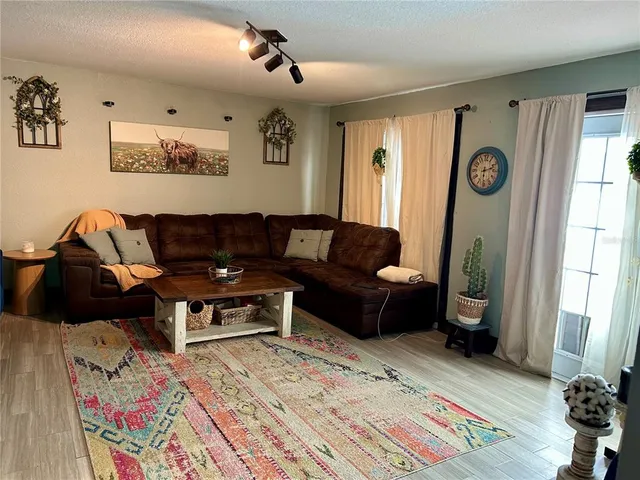 a living room with furniture a flat screen tv and a table