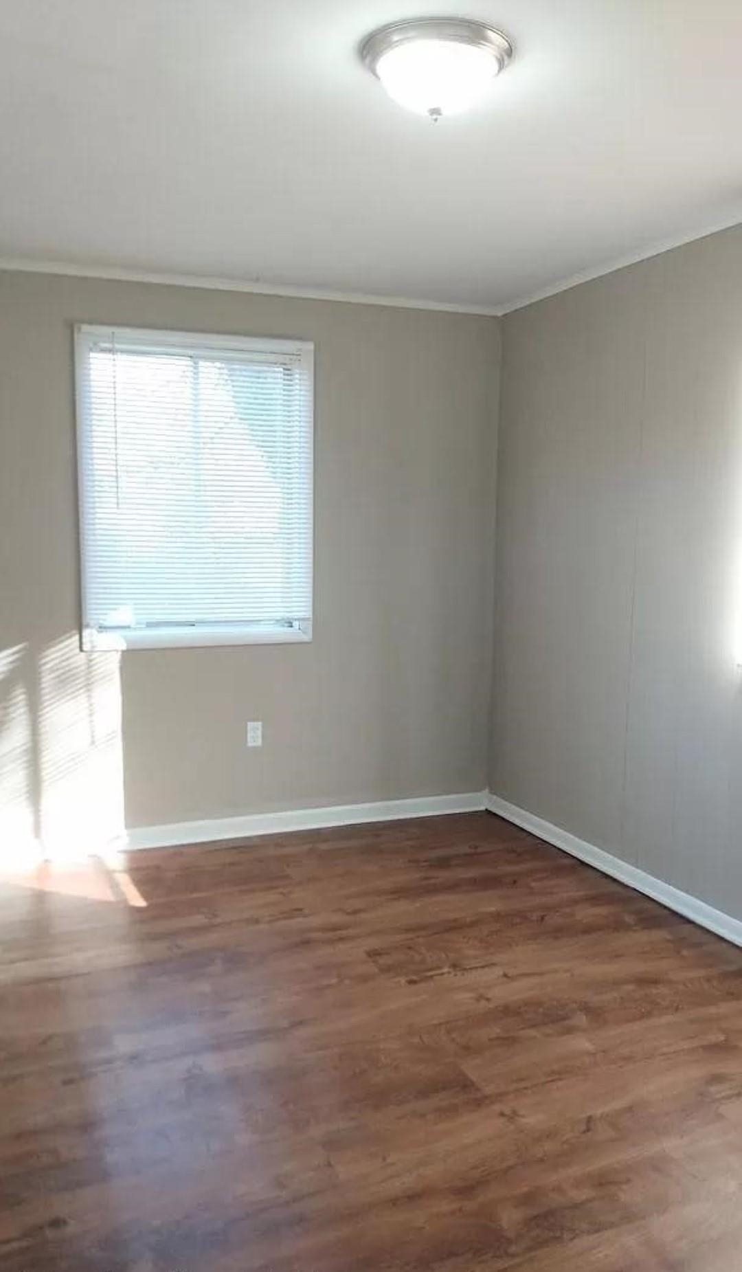 3430 Carrington Road Memphis, TN 38111 - Photo 5 of 13 a view of an empty room with wooden floor and a window
